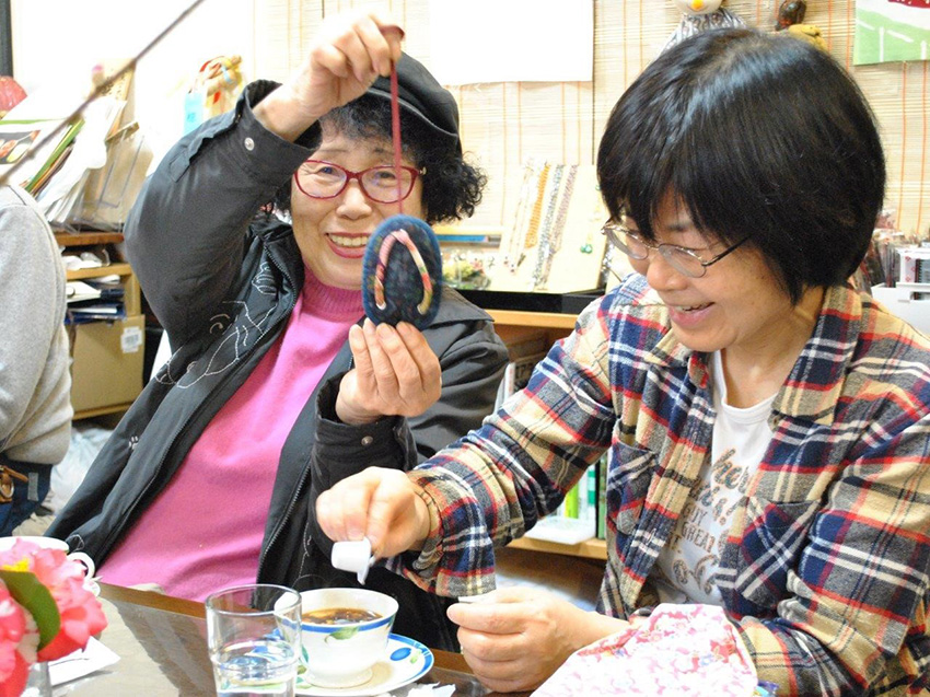 手編みの小物を手に参加者同士会話が弾む