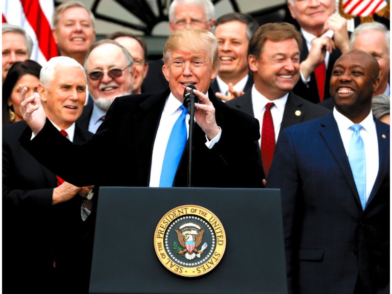 最重要政策に掲げた税制改革法が成立し、共和党議員らと祝うトランプ大統領
