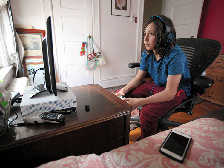 米ニューヨーク・ブルックリンの自宅で、ビデオゲーム「フォートナイト」をプレーする12歳の少年。「階下に住んでいる友人とよくプレーする」という=ロイター