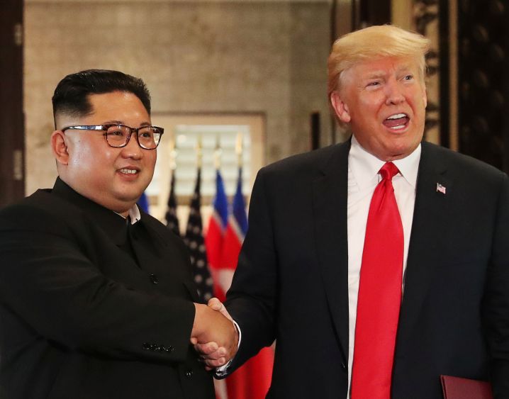 シンガポールで12日開かれた米朝首脳会談で共同文書に署名後、握手するトランプ氏と金正恩氏=ロイター