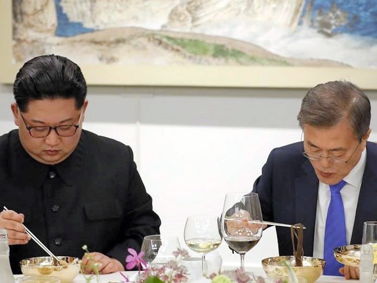 4月27日、一緒に平壌冷麺を食べる金正恩氏(左)と文在寅氏=韓国大統領府提供