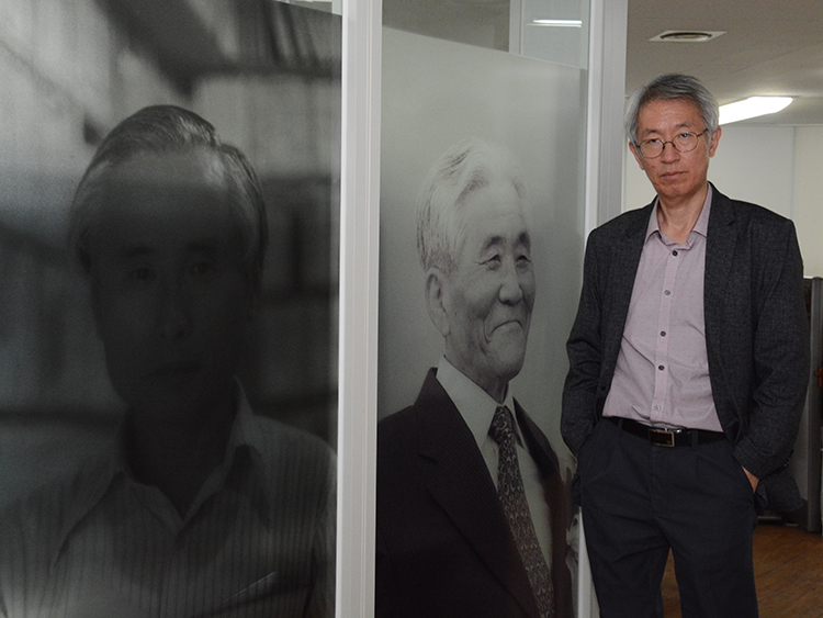 ニュースタパのキム・ヨンジン代表。編集部には、韓国の民主化に貢献したジャーナリストの写真が飾ってある=吉田美智子撮影
