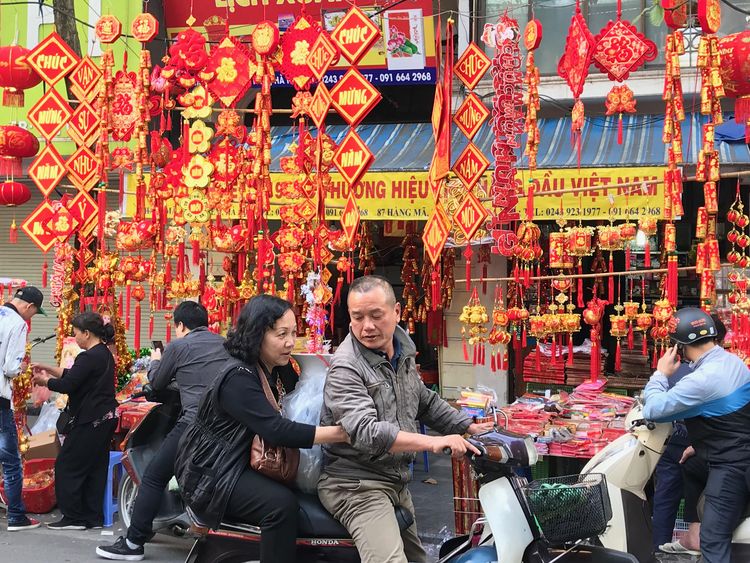 お正月飾りで真っ赤になった旧市街のハンマー通り=ハノイ、鈴木暁子撮影