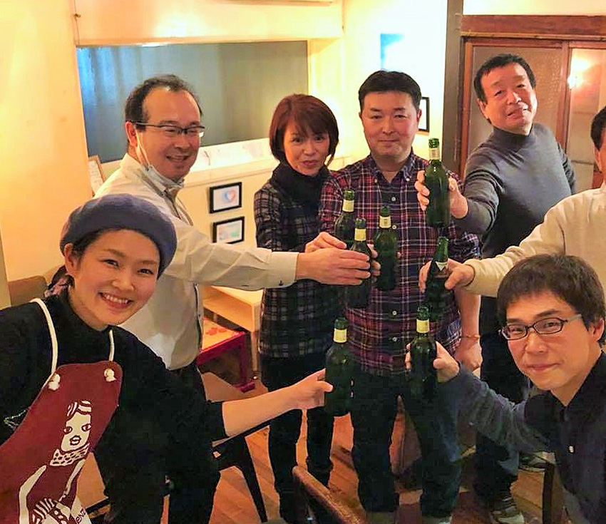 飲み会恒例の記念撮影。厨房を抜け出して乾杯するゆかさん(写真左端)=水野隆史さん提供