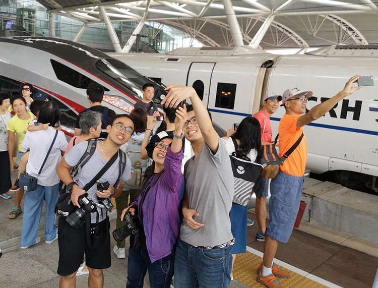 香港と中国大陸を結ぶ高速鉄道の開業日、広州南駅のホームで自撮りする乗客=2018年9月23日、広州市、吉岡桂子撮影
