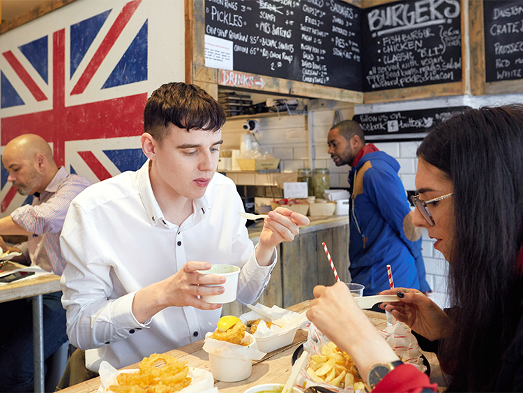 ロンドンのハックニー区にできた完全菜食主義者向けのフィッシュ&チップス料理店「サットン・アンド・サンズ」の店内=2018年10月4日、Olivia Harris/©2018 The New York Times。「フィッシュ」は魚の代わりにバナナの花が主に使われており、経営者はこの種の店はロンドンで初めてとしている