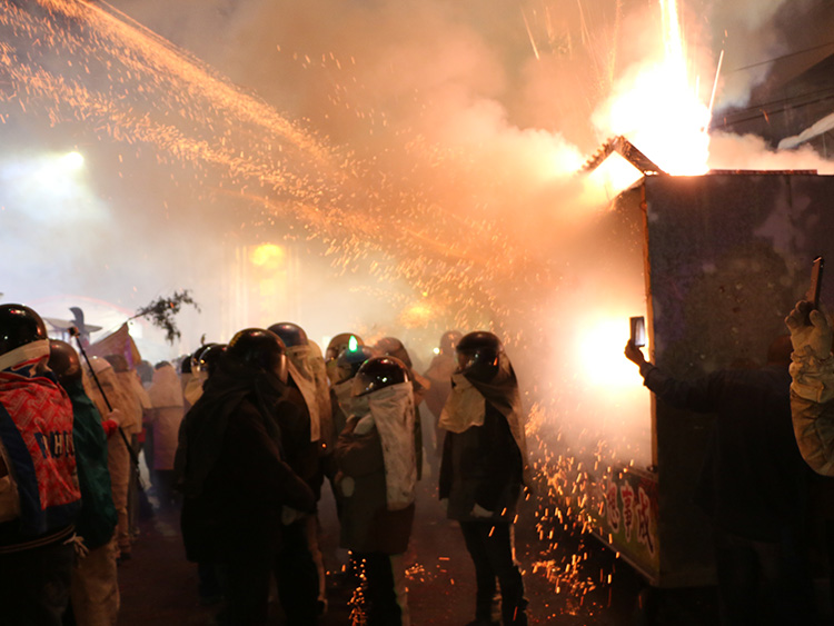 台湾南部、台南市塩水区のロケット花火祭り。花火を体で浴びると縁起が良いとされ、防火服姿の人々が発射台の前に立つ=2月18日、西本秀撮影