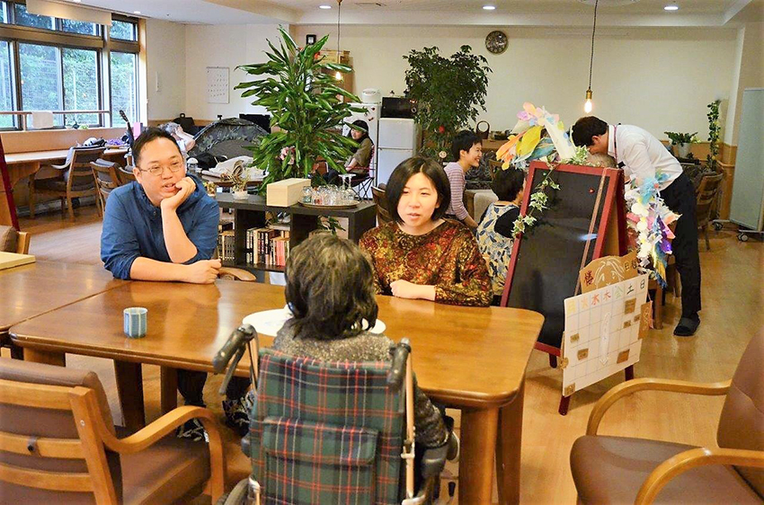 食堂で入居者の女性と談笑する柳雄斗さん(左)と楼婕琳さん(右)