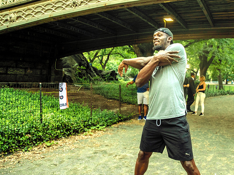 Usain Bolt stretches with members of New York Road Runners in Central Park, New York on July 25, 2019. The world's fastest man has retired from competition, but Bolt is still on the move — and playing pickup soccer. (Brittainy Newman/The New York Times)
