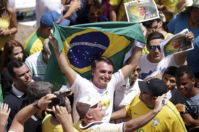 ブラジルの首都ブラジリアで2016年3月、ルセフ大統領(当時)の弾劾を求めるデモに参加したジャイール・ボルソナーロ(中央)=ロイター