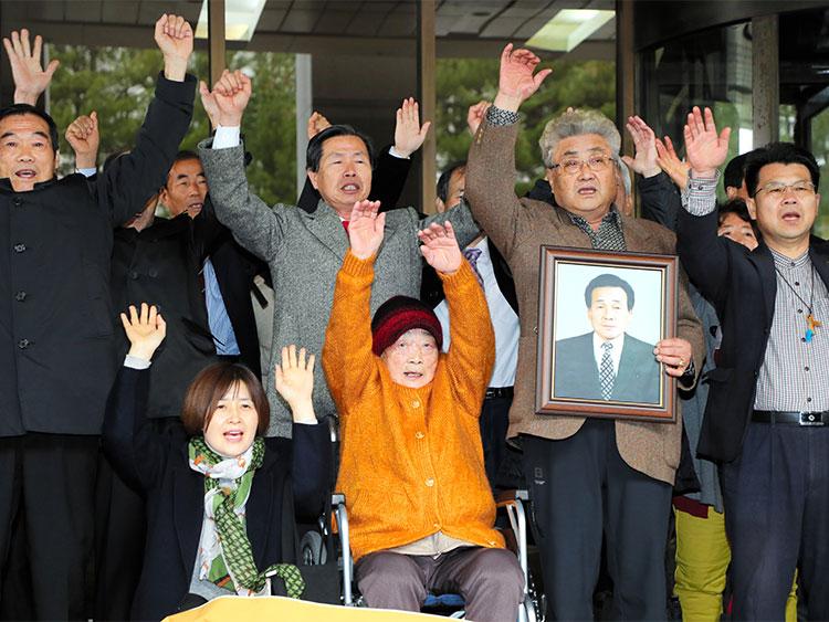 11月29日、勝訴判決を受けて万歳する原告団=東亜日報提供