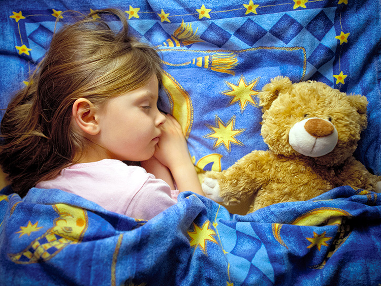 The illustration shows 6-year old Amy sleeping in her bed next to her cuddly toy in Sieversdorf, Germany, 28 March 2013. Photo by: Patrick Pleul/picture-alliance/dpa/AP Images