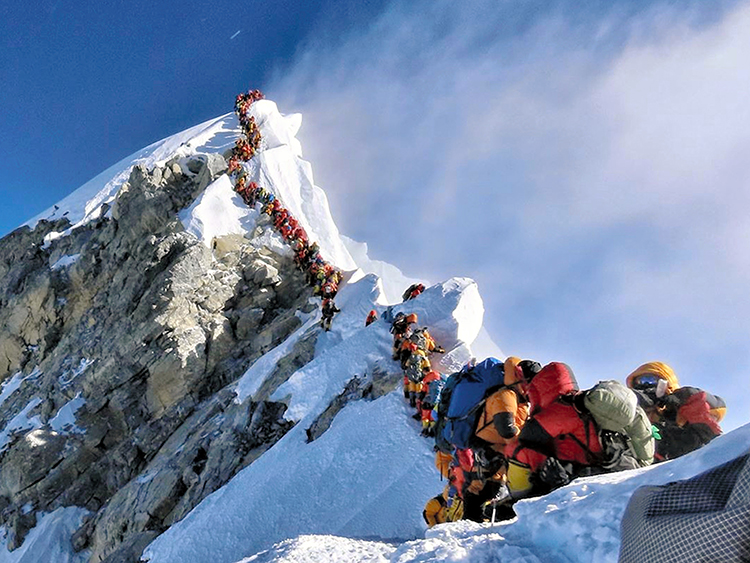 In this photo made on May 22, 2019, a long queue of mountain climbers line a path on Mount Everest. About half a dozen climbers died on Everest last week most while descending from the congested summit during only a few windows of good weather each May. (Nirmal Purja/@Nimsdai Project Possible via AP)