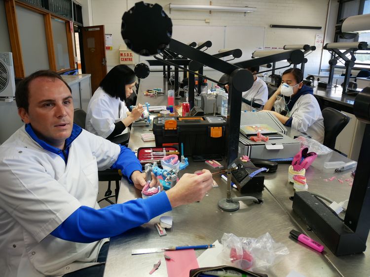 TAFEの歯科技工士養成コースで学ぶフランス人のダミエン・バレンティンさん。「総入れ歯」を実習で作っていた=シドニーのTAFEランドウィックキャンパス、小暮哲夫撮影