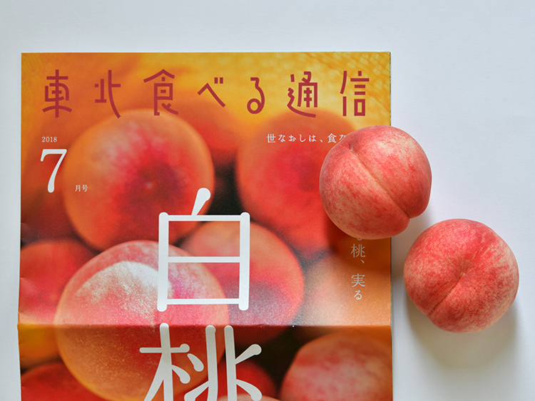 福島県桑折町の農家、羽根田幸将を特集した「東北食べる通信」の7月号と白桃。毎号旬の食べ物が届く=角野貴之撮影