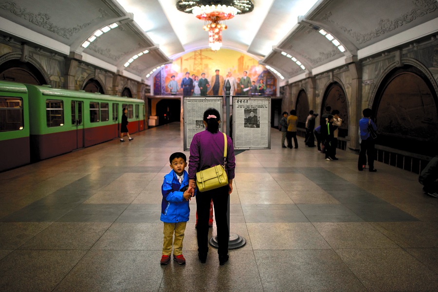 平壌の地下鉄駅にたたずむ女性と子供。photo:AFP=時事/Ed Jones