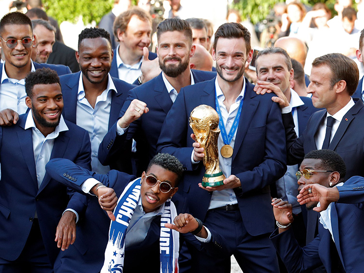 サッカーW杯ロシア大会で優勝したフランス代表チームメンバーと、マクロン仏大統領=ロイター