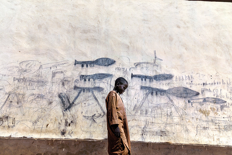 Bol, Chad, 13th October 2018. Orphaned children, mainly Nigerian refugees, live together as a group in the Koran schools. During the day, they go begging and are known as Almajiri. These children, who live in the Lake Chad basin, are growing up in a constant situation of war, and all they've ever known is the weapons and deaths they draw on the walls of the city. Almajiri is gotten from an Arabic word