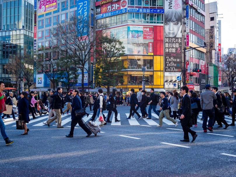都会のスクランブル交差点を行き交う人々