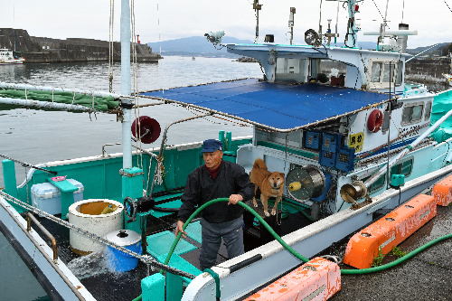 徳永さんと愛犬のジョン。12年間、毎日のように一緒に漁に出る
