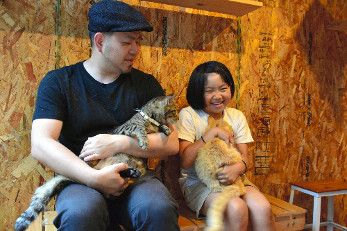 「猫庭」で猫を抱く手島英樹さんと姫萌さん=山口市阿知須
