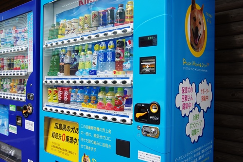 ピースワンコカラーでラッピングされたチャリティ自販機