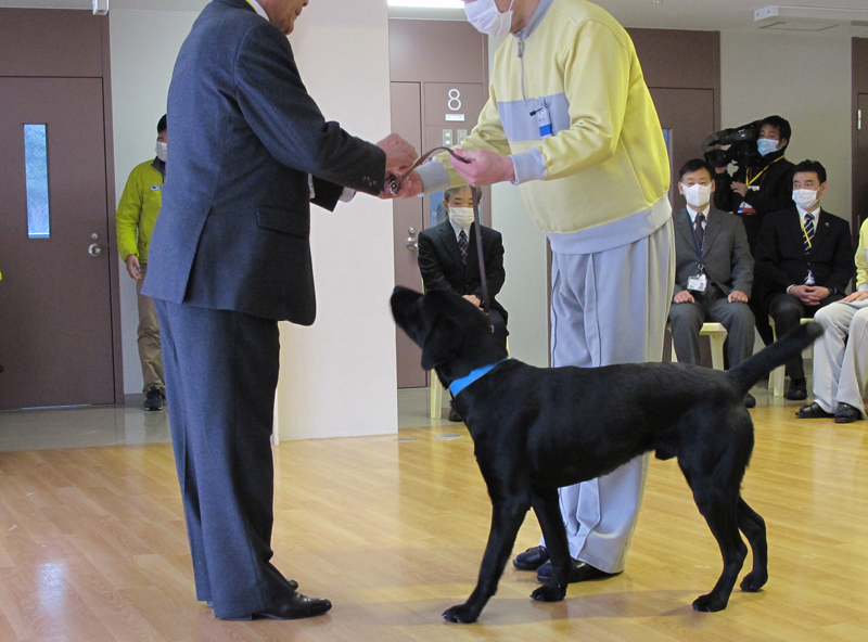 修了式で、日本盲導犬協会の井上幸彦理事長にパピーを引き渡す訓練生(c)大塚敦子