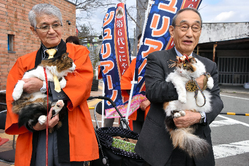見つめ合うニタマ駅長(右)とジュリアーノ市長=和歌山県紀の川市