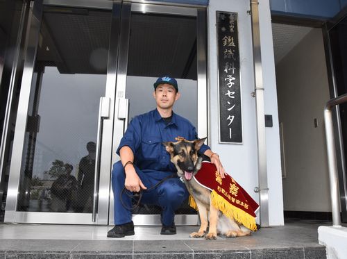 ヨハン号と警察犬係の庵野巡査部長=和歌山市西の鑑識科学センター