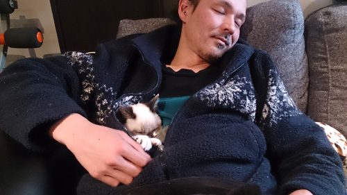 迎えた初日から、学さんの懐でくつろぐスイくん(山田敦子さん提供)