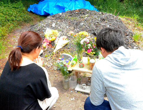 ペット霊園の跡地で愛犬を思い、手を合わせる河野祐紀子さん(左)と次男=大阪府枚方市