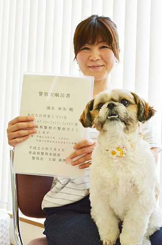 警察犬の嘱託書を持つ浜名さんと「まる」=青森県弘前市
