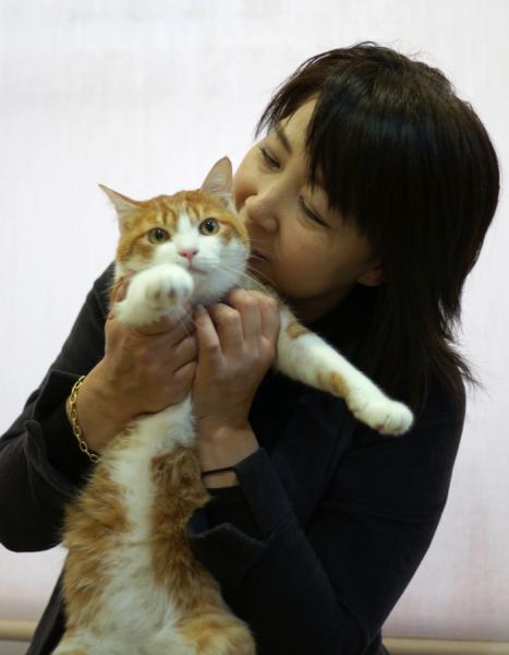 「CATS&DOGS CAFE」店長の吉田智恵子さんと、保護猫のレスターくん