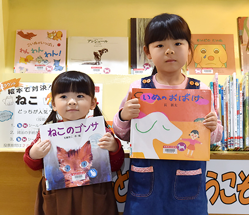 選んだ絵本を持つ久保佐織ちゃん(右)と璃紗ちゃん=群馬県立図書館