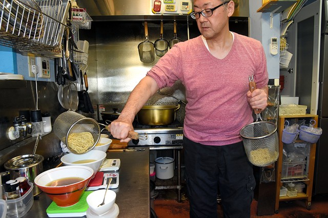 在厨房里做拉面的吉田克己=摄于10月25日(横山翼)