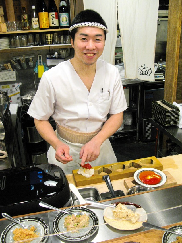 おにぎりを作る山中竜也さん＝大阪市北区