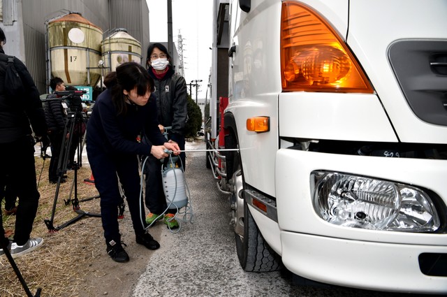 愛知縣豐田市,人們在發生豬瘟的養豬場前,對進出的車輛輪胎進行消毒=